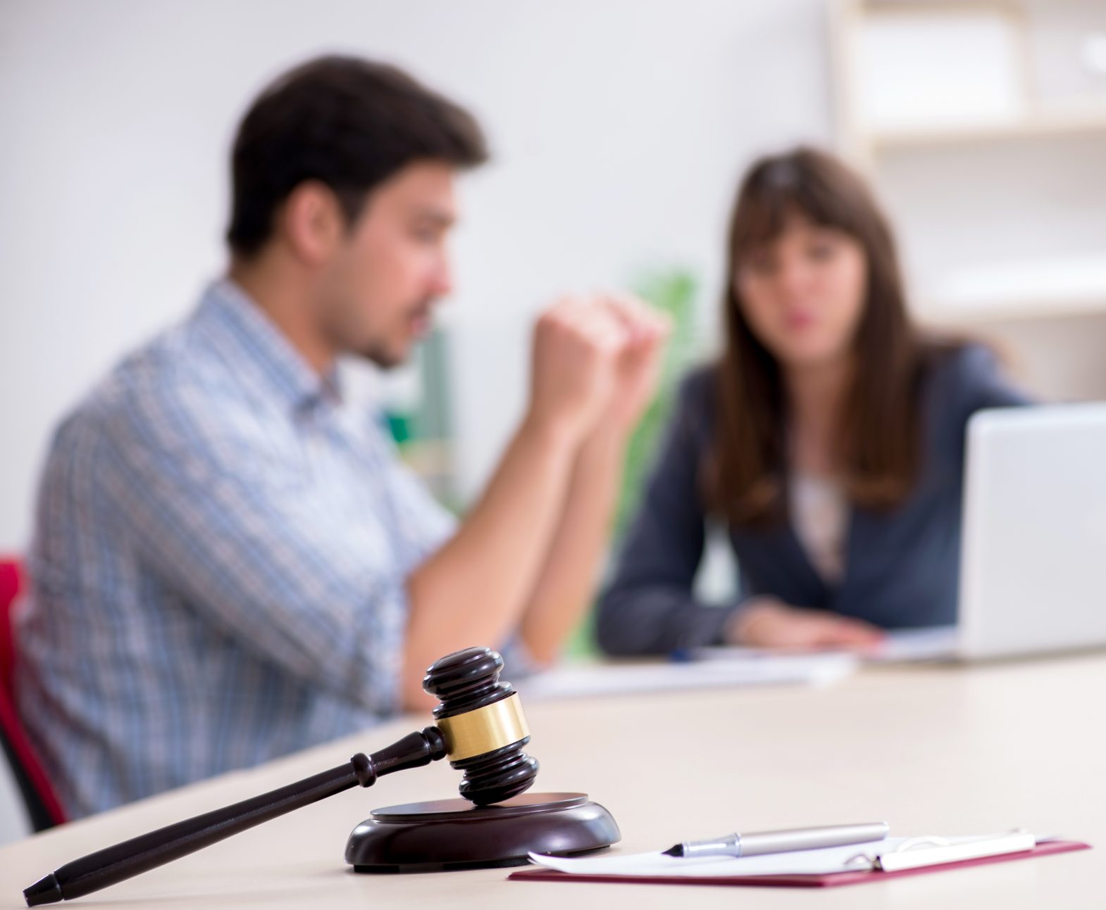 Client and solicitor in meeting with document in the foreground.