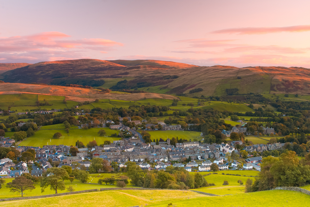 Aerial view of a village in the English countryside at sunset.